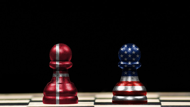 Close up to a two pawns chess pieces with the flags of denmark and united states over a chess board and black background in geopolitical concept