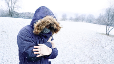 barbat cu manusi si haine groase in ger