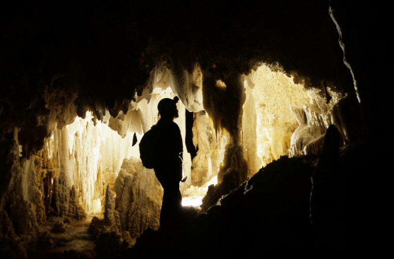 Female caver looking at stalactites in the New Mexico Room Carlsbad Caverns national park New Mexico USA