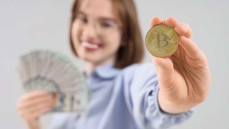 Young woman with bitcoin and dollar banknotes on light background, closeup
