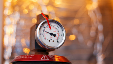 High pressure gauge in the oil system of industrial equipment, pumps and pipelines with a red line. Technical indications