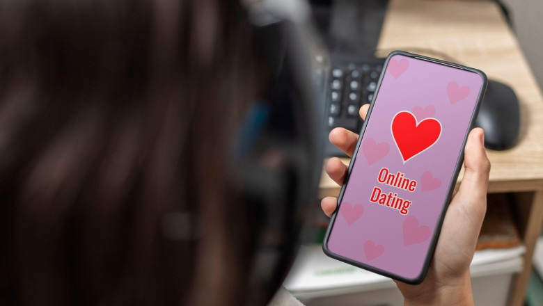 An unrecognizable female teen is holding a mobile phone with online dating text displaying on its screen with pink background