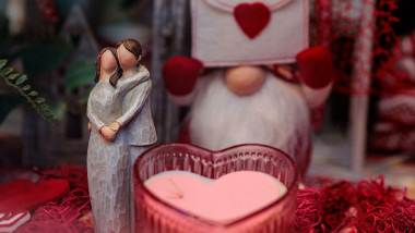 Festive Valentine s Day tabletop display with heart candles, romantic figurines, ceramic lanterns, and lush greenery, arranged in a cozy, colorful dec