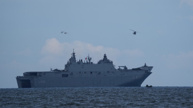 A helicopter flies over the L400 "Anadolu", an amphibious assault ship from Turkey, during the NATO maneuver