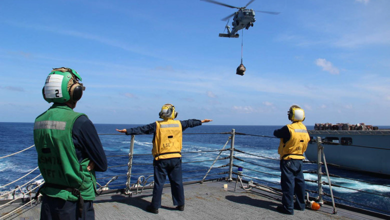 U.S. Navy sailors directed helicopter operations aboard USS Kidd (DDG 100) during search and rescue operations for the missing Malaysian Airlines flight MH370 with 227 passengers and 12 crew.