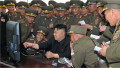 Kim Jong Un înconjurat de militari se uită pe un ecran de calculator
