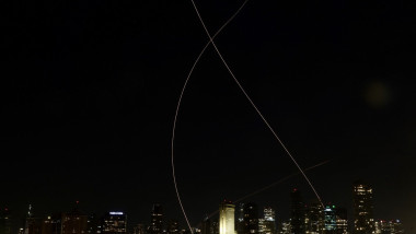Missile trails and interceptions by Israel’s Iron Dome air defense system light up the sky over Tel Aviv