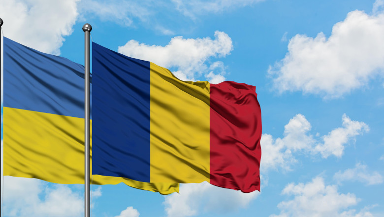Ukraine and Romania flag waving in the wind against white cloudy blue sky together. Diplomacy concept, international relations.