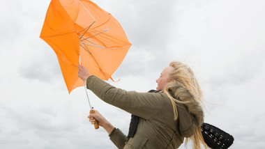 femeie cu o umbrela luata de vant
