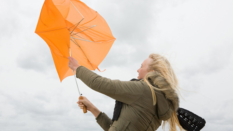 femeie cu o umbrela luata de vant