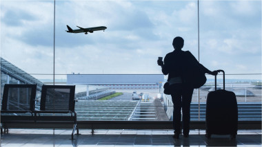 călător în aeroport cu un avion în fundal