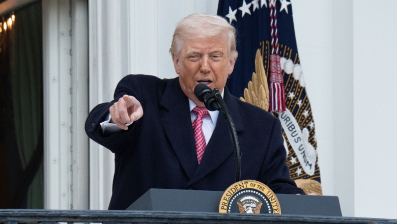 d trump la pupitru cu microfon, face gest cu mana