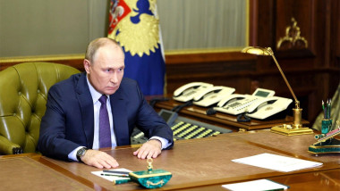 v putin sta la birou, telefoane in spate, press papier in fata lui