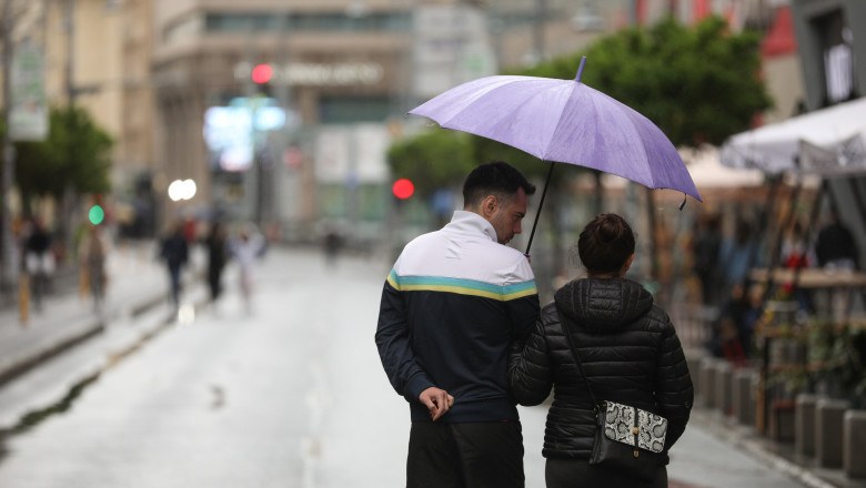 oameni cu o umbrela pe strada in bucurești