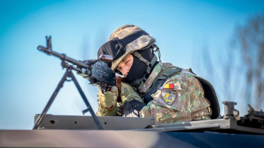 soldat roan in uniforma de camuflaj cu arma la ochi