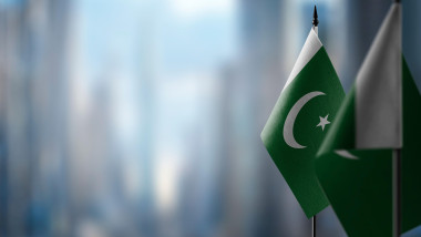 Small flags of the Pakistan on an abstract blurry background.