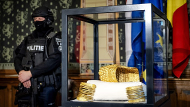 ASSEN - The recovered golden helmet by Cotofenesti, which was stolen from the Drents Museum, stands next to a heavily armed police officer. On January 25, 2025, the golden helmet was stolen along with three golden bracelets. The museum had the highly valu