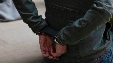 om cu mâinile cu cătușe la spate