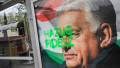 A tag reads 'Liar Fidesz' over a placard about a national petition against war, showing outgoing Hungarian Prime Minister and Fidesz leader Viktor Orban, at a bus stop near the South Railway Station in Budapest