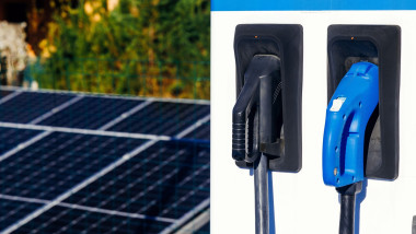 Rooftop solar panels are positioned next to electric vehicle charging stations, highlighting the integration of renewable energy and eco-friendly tran