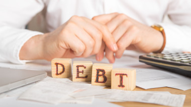 Businessman holding wooden cube with Tax word.