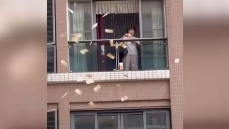 o femeie arunca bani de la balcon