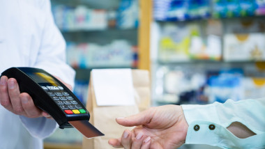 Customer taking credit card from payment terminal in pharmacy