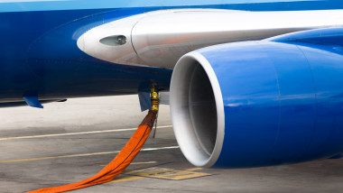 Orange hose ready to refill kerosene gas in to tanks of a jet plane.