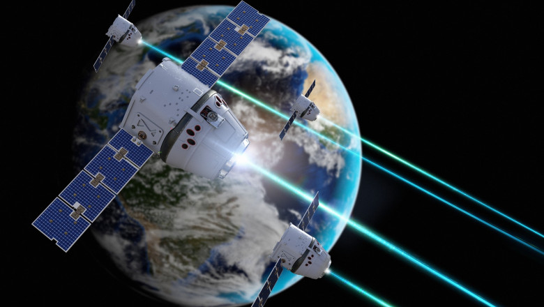 ilustrație cu sateliți pe orbita terestră și arme laser