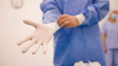 Surgeon getting ready for a procedure by putting on sterile gloves