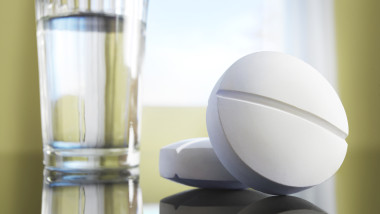 Two aspirins with a glass of water