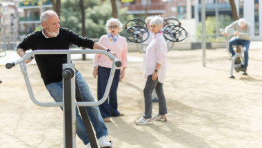 Senior man training on outdoor gym equipment