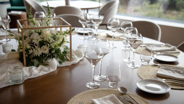 Elegant dining table set for a special event, featuring a beautiful floral centerpiece, wine glasses, and finely arranged utensils