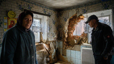 Tanya Los (L), 57, and her husband Valery, stand in their house near damage caused by a rocket which destroyed their house in the village of Mala Tomachka