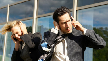 Business people with phones in wind,