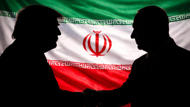 Silhouette profiles of Donald Trump and Benjamin Netanyahu shaking hands against a full-frame Iranian flag, symbolizing geopolitical strategy