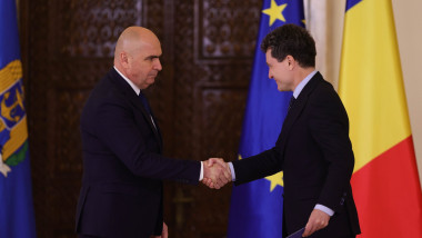 Președintele Nicușor Dan dă mâna cu premierul Ilie Bolojan.