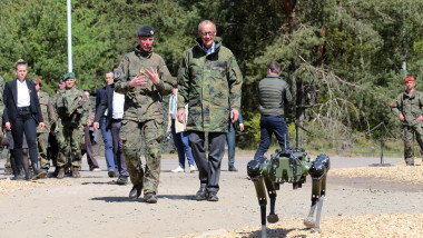 Bundeskanzler Friedrich Merz in Begleitung des Inspekteur des Heeres, Generalleutnant Christian Freuding (links) in Munster. Rechts vorne bewegt sich ein sogenannter Roboterhund mit der Bezeichnung Ghost Vision 60 von Ghostrobotics.