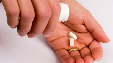 Glucosamine tablets being tipped into hand
