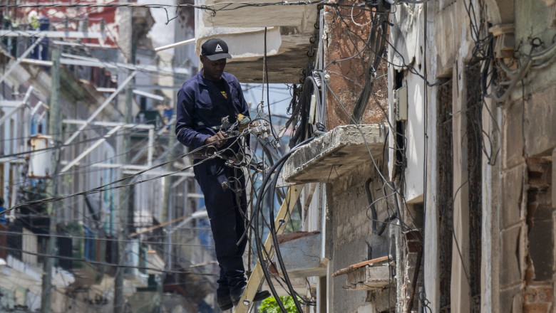 Un electrician se străduiește să reconecteze locuințe la rețeaua electrică după pana de curent. Foto Profimedia