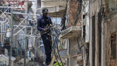 Un electrician se străduiește să reconecteze locuințe la rețeaua electrică după pana de curent. Foto Profimedia