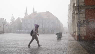 plaoie puternica in timisoara si un om care merge in ploaie