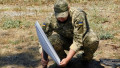 Un soldat ucrainean instalează o antenă Starlink pentru conexiune la internet prin satelit