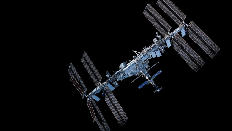 International Space Station floats above Earth's blue oceans and white clouds. Elements of this image furnished by NASA