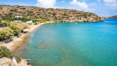 Idyllic view of sandy beach and catamaran boat in sea bay near Chrysopigi monastery, Sifnos island, Greece