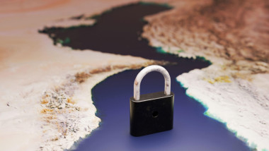 symbolic black padlock stands in the narrow Strait of Hormuz on a map of Iran. Conceptual image representing oil transit blockage, geopolitical tensio