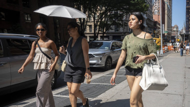 femei pe strafa in NY pe canicula mare, cu umbrela de soare