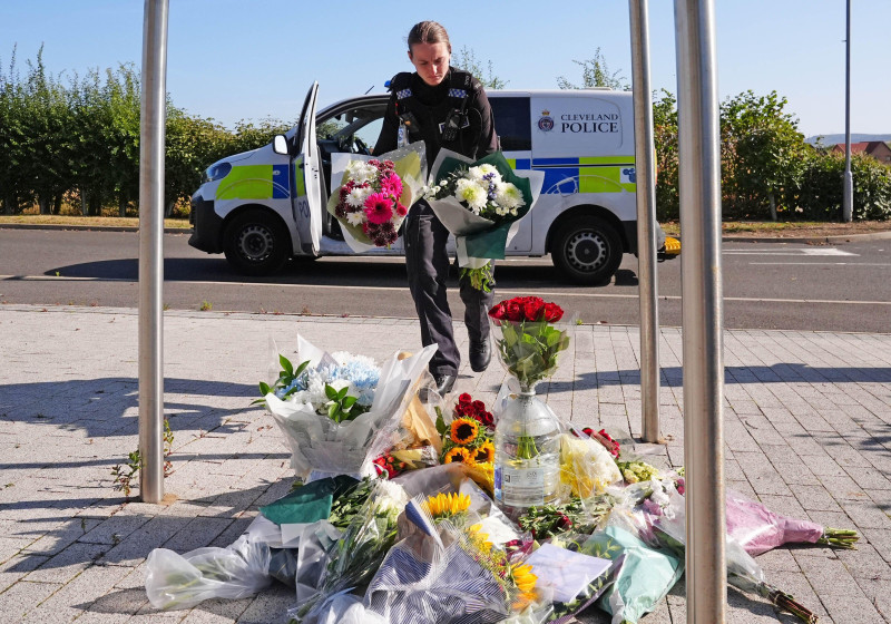 A police officer leaves flowers at the Cleveland Police HQ Memorial Garden in Middlesbrough, following the line-of-duty deaths of PC Matthew Blades and PC Tom Clough were killed when a Volkswagen Passat – which had been pursued by police – was driven the