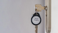 House keys with Rental Property keychain inserted into apartment door lock with copy space. Real estate rental and property management concept for