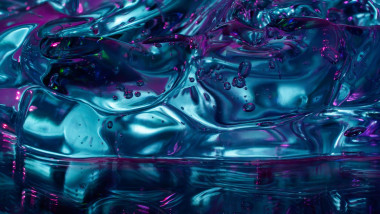 Close-up abstract composition of translucent turquoise ice cubes with trapped bubbles, illuminated by vivid magenta and blue reflections for a cool, g